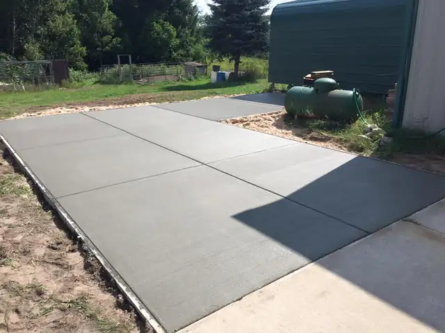 Jointed concrete pad poured beside an outbuilding